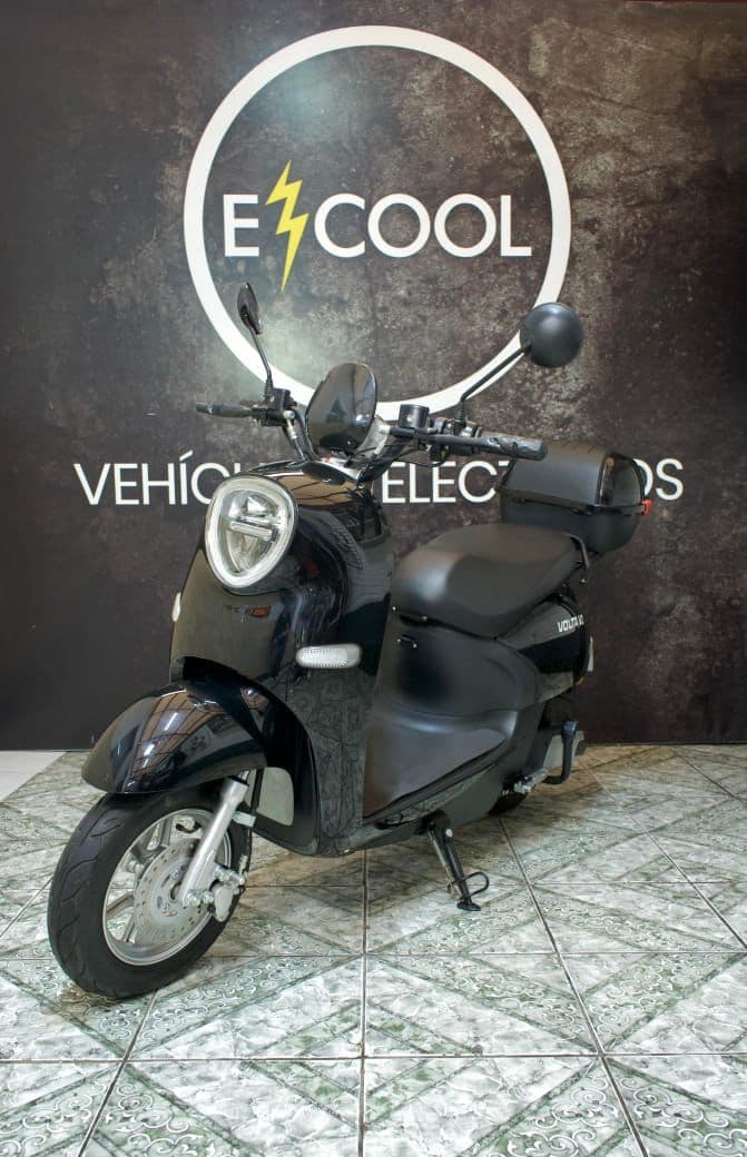 Scooter retro ECOOL negra en showroom con logo de fondo