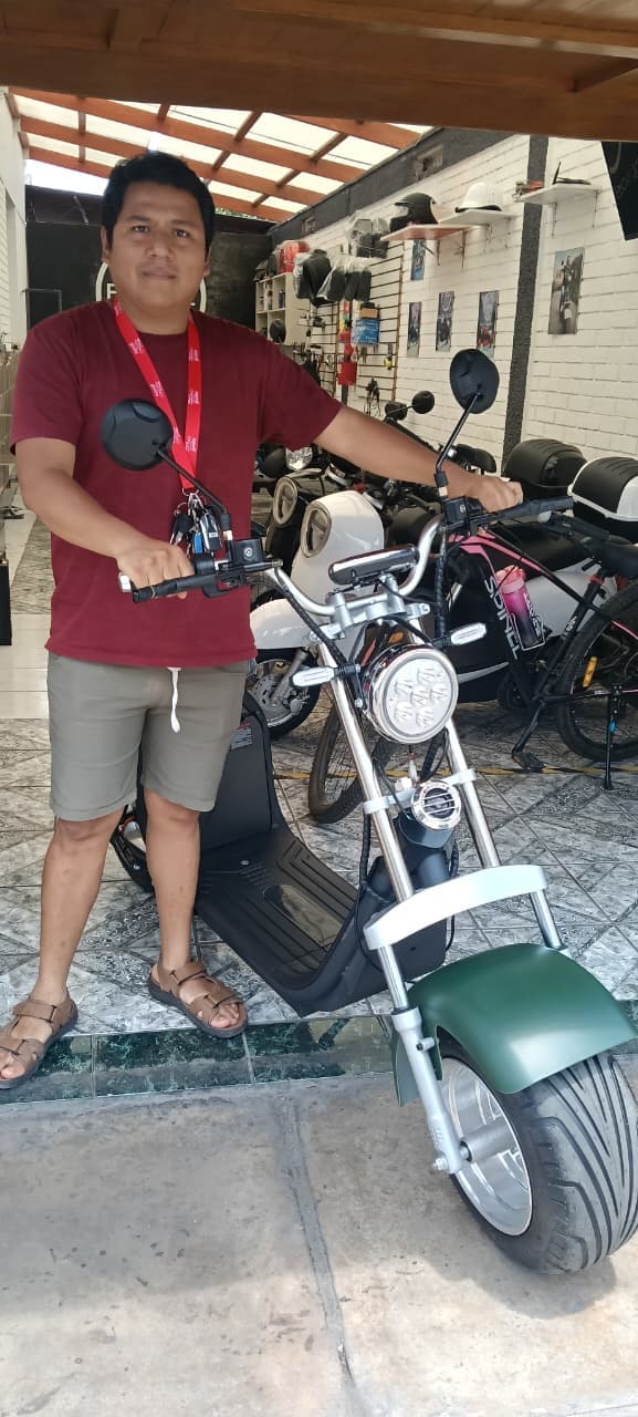 Cliente con su nueva ECOOL chopper verde en el showroom