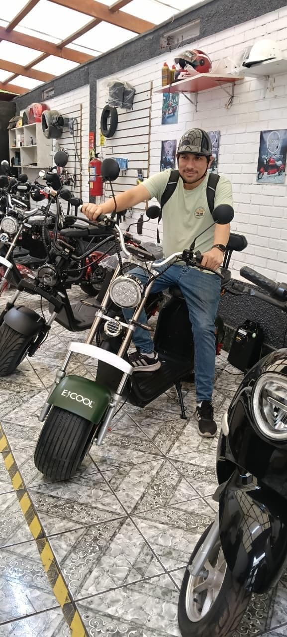 Cliente con mochila en su ECOOL chopper verde en el showroom